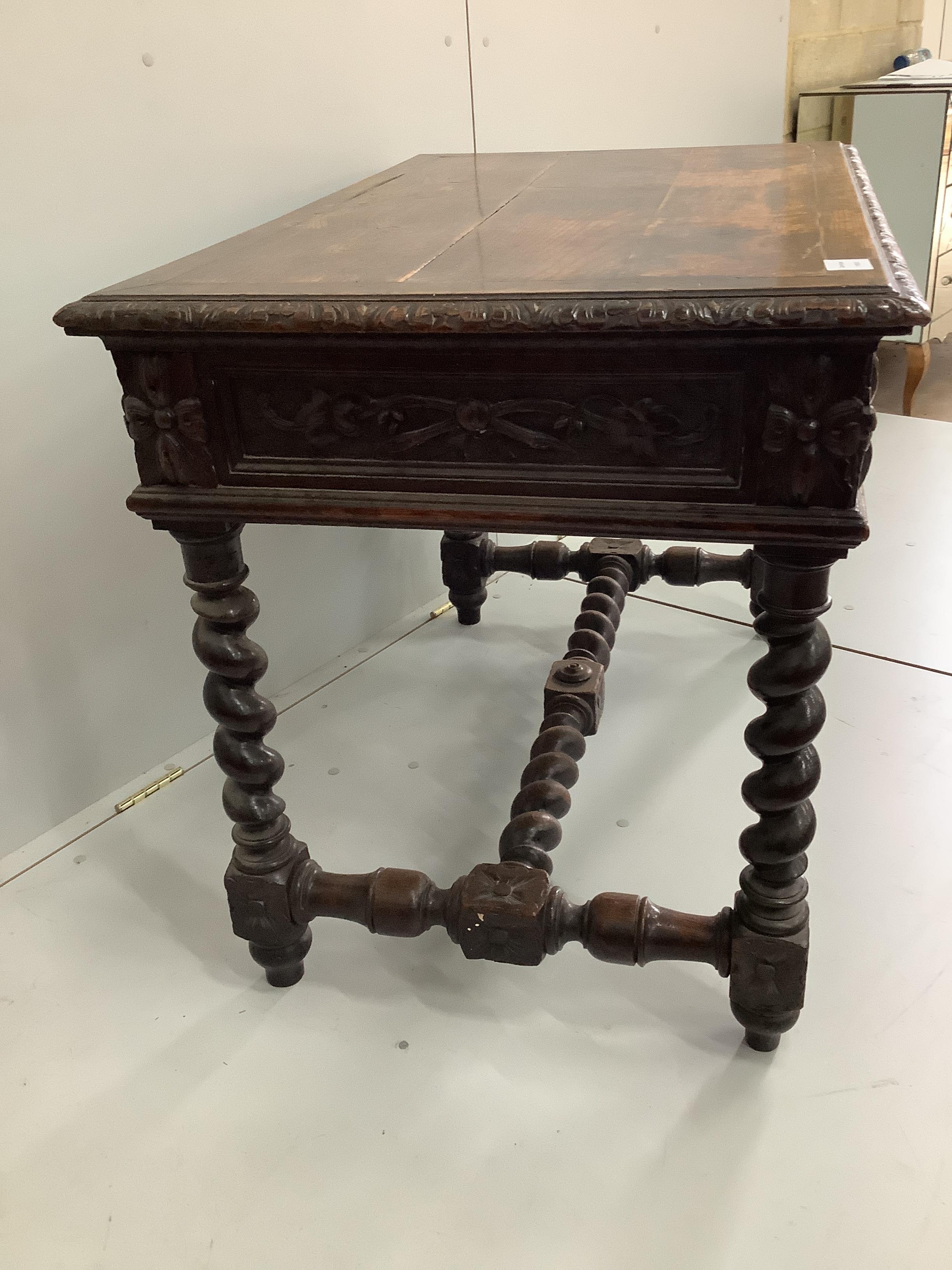 A late 19th century Flemish carved oak two drawer side table, with a barley twist under frame, width 99cm, depth 64cm, height 75cm